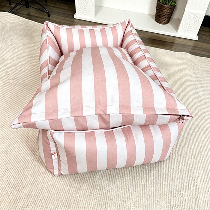 Eco-friendly dog kennel bed in pink and white stripes, pillow section close-up view